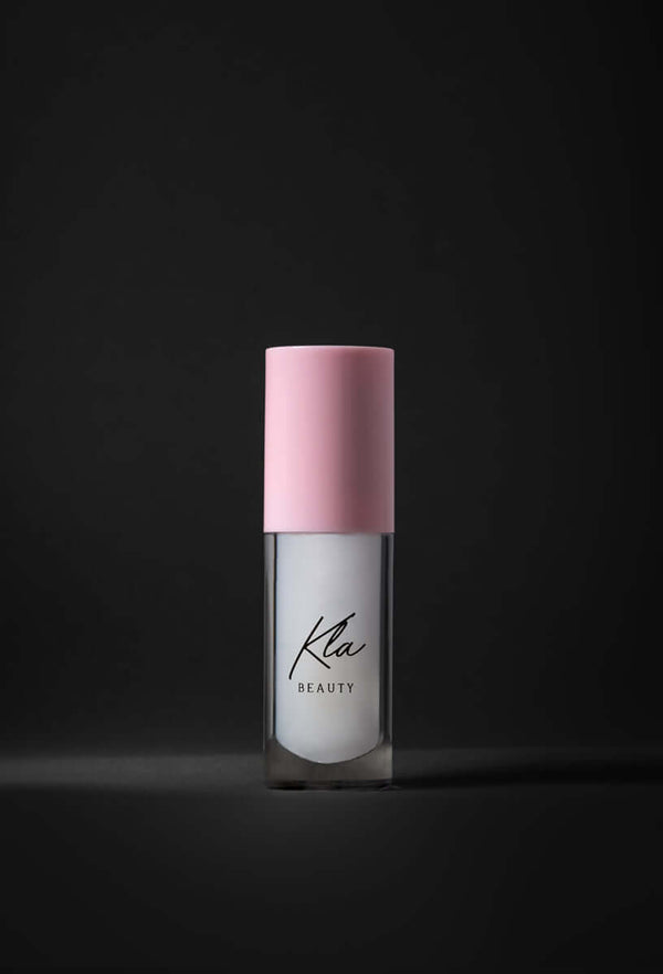 KLA Beauty Lip Oil with milky color, vegan formula, pink cap, dark background.