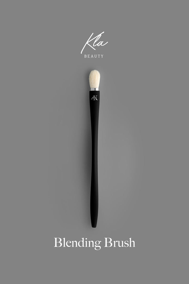 KLA-beauty blending brush with sleek black handle and soft bristles, displayed on a gray background.