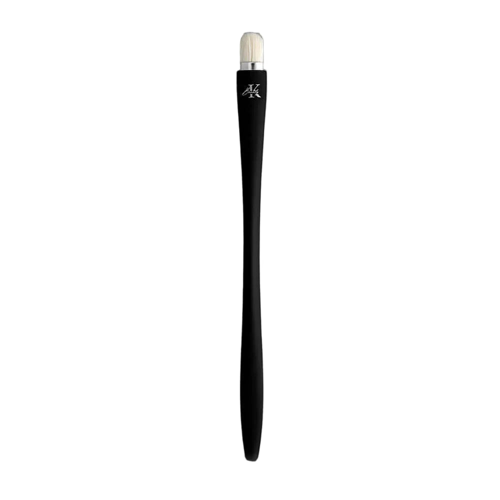 KLA-beauty concealer brush with sleek black handle and fine bristles on gray background