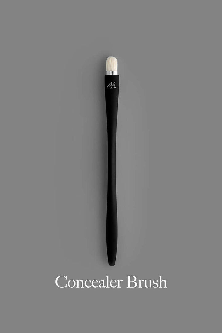 KLA-beauty concealer brush with sleek black handle and white bristles.