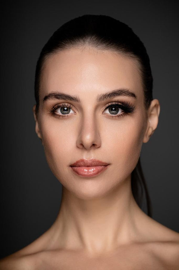 Close-up portrait of a woman with flawless makeup, highlighting KLA-Beauty artistry.